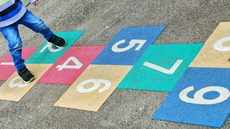 Kind beim Hüpf-Kästchen spielen