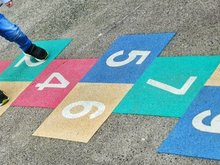 Kind beim Hüpf-Kästchen spielen